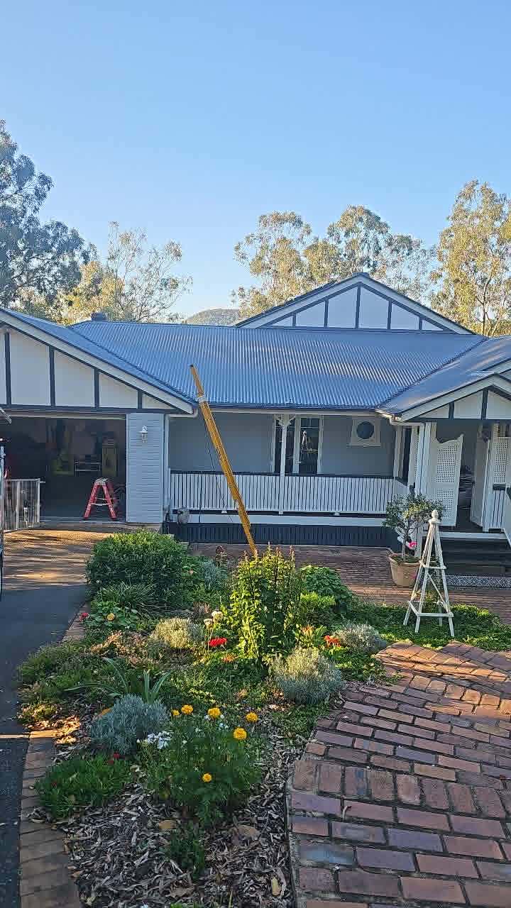 Queenslander-style home with a cottage garden in the Ipswich region, ladder on the verandah during electrical work